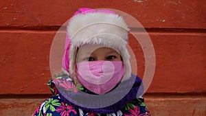 Young girl in warm clothes protective face mask.