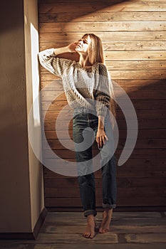 Young girl in warm knitted sweater at home. Cozy style