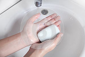 Young girl washing hands with a soap. Hygiene