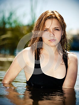 Young girl in the water in summer river