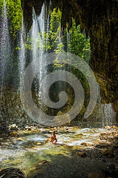 Young girl in waterfall near Panta Vrexei in Evritania, Greece