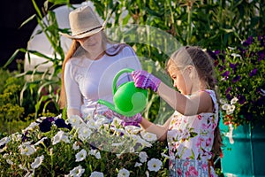 Young girl watering potted flower plant smiling