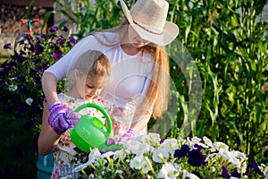 Young girl watering potted flower plant smiling