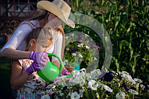 Young girl watering potted flower plant smiling