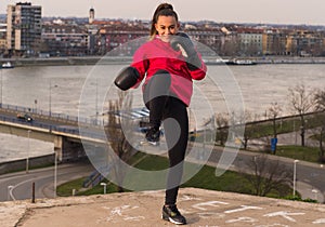 Young girl wearing boxing gloves throwing a punch - martial arts