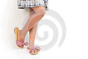 Young girl wearing fasionable stripy sandals and dress with white background