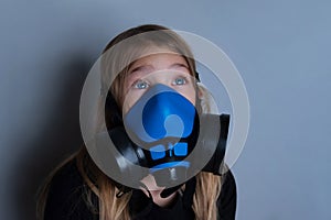 Young girl wearing gasmask, respirator portrait