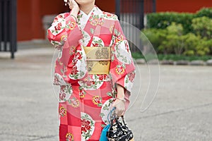 Young girl wearing Japanese kimono standing in front of Sensoji Temple in Tokyo, Japan. Kimono is a Japanese traditional garment.