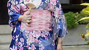 Young girl wearing Japanese kimono standing in the park