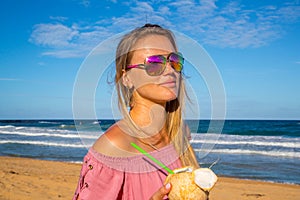 Young girl wearing sunglasses walking down the beach