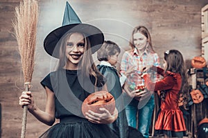 Young Girl wearing Witch Costume Holding Broom