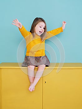 A young girl wearing a yellow shirt