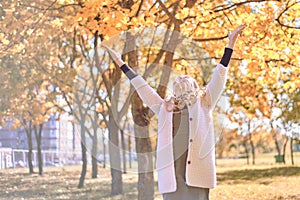 Young girl welcomes autumn. teenager raised her hands up. hello autumn concept