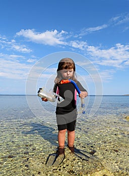 Young girl with wetsuit, masks and snorkels at the s photo