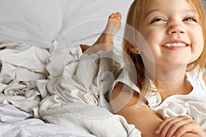 Young girl in white covered bed