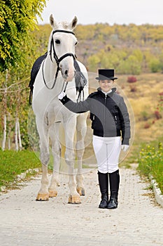 Young girl with white dressage horse