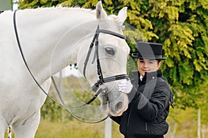Young girl with white dressage horse