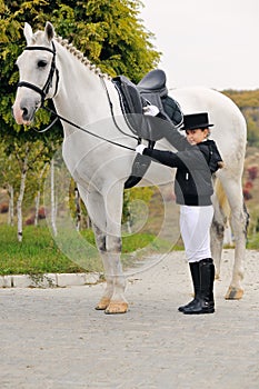 Young girl with white dressage horse