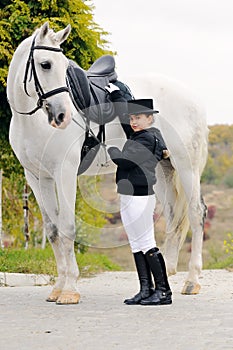 Young girl with white dressage horse