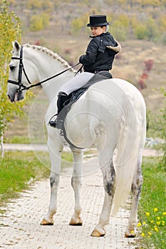 Young girl with white dressage horse