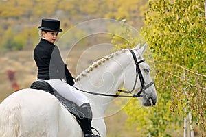 Young girl with white dressage horse