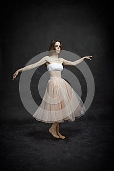 Young girl in white top and peach skirt dancing