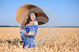 Young girl in a wide-brimmed hat in a wheat field