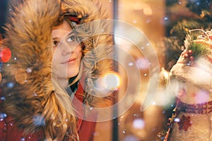 Young girl at the window of Christmas shop