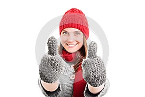 Young girl in winter clothes giving a thumbs up