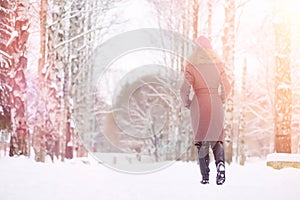 A young girl in a winter park on a walk. Christmas holidays in t