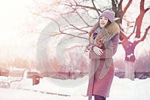 A young girl in a winter park on a walk. Christmas holidays in t