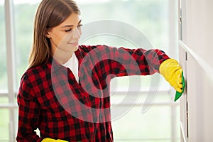 Young girl wiping shelf and folders, office cleaning concept