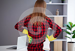 Young girl wiping shelf and folders, office cleaning concept