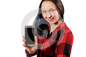 A young girl woman in a red and black shirt is holding a smartphone with a blank black screen vertically in front of her