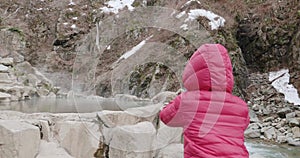 Young girl and woman take photos of snow monkey in a hot spring in Japan