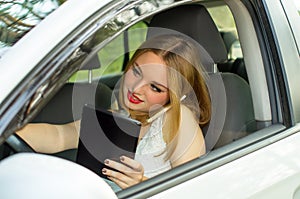 A young girl working while driving car