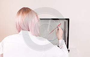 Young girl is working at home on computer, using her all-in-one desktop.