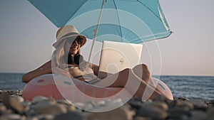 Young girl working on laptop outdoors in summer vacation