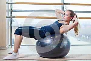 Young girl working out at the gym with a ball