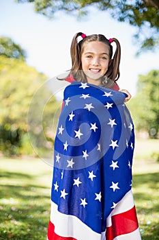 Young girl wrapped in American flag