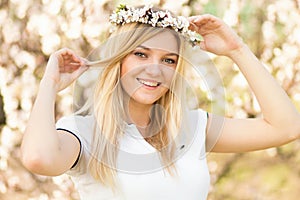 Young girl in a wreath of flowers with apricot