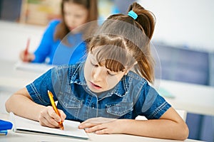 Young girl writing at school