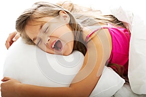 Young girl yawning while waking up