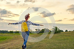 Young girl with yellow backpack, her back with open hands