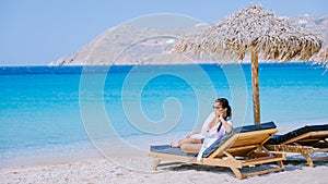 young girlon the beach of Mykonos, Elia beach Mikonos, Mykonos beach during summer with umbrella and luxury beach chairs