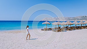 young girlon the beach of Mykonos, Elia beach Mikonos, Mykonos beach during summer with umbrella and luxury beach chairs