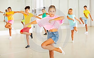 Young girls and boys performing dance in studio