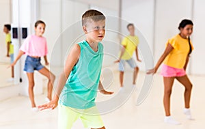 Young girls and boys performing modern dance in studio