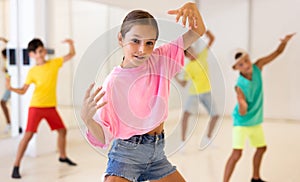 Young girls and boys performing modern dance in studio