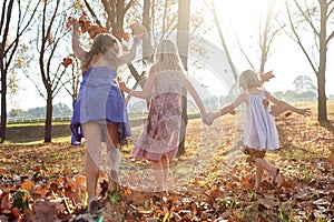 Young girls children kids playing running in fallen autumn leave